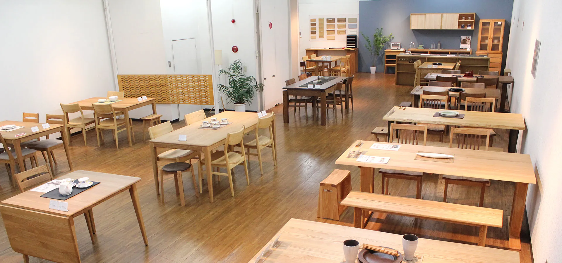 木製家具が展示されたショールーム内観、ダイニングテーブルやチェア