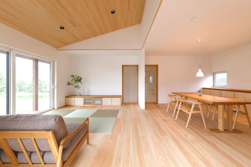 木目天井と畳スペースのある、無垢材の家具で統一された明るく開放的なリビングダイニング