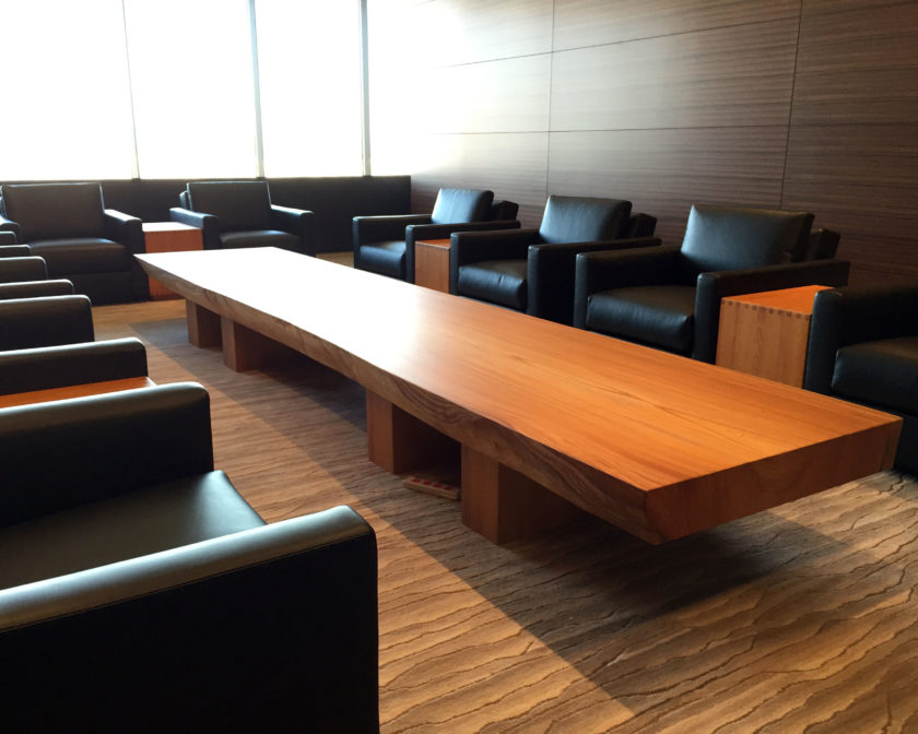 黒革ソファと大型木製テーブルが配置された、明るく落ち着いたモダンな会議室空間