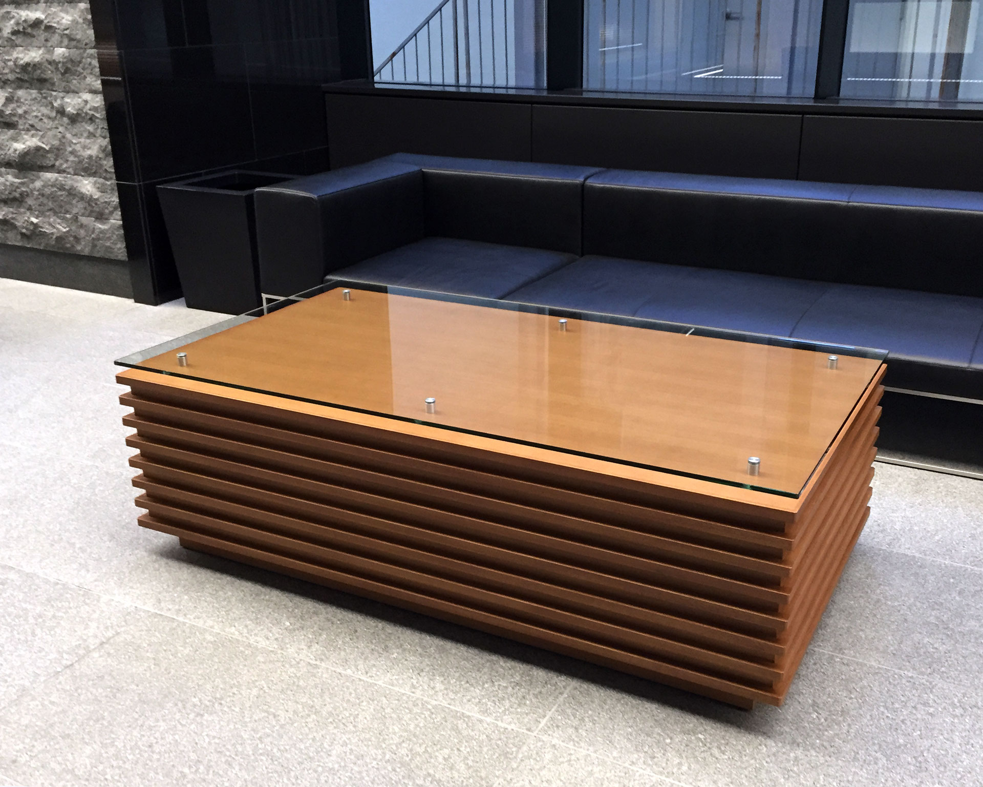 ガラス天板とルーバー状木製ベースのモダンなセンターテーブル